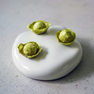 Drei Kopfsalatschälchen mit Labneh-Bällchen und Salzgurkenpulver