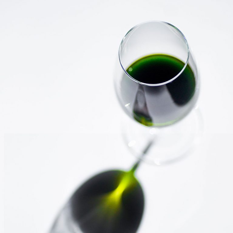 Glas mit leuchtend grünem Bärlauchöl.
