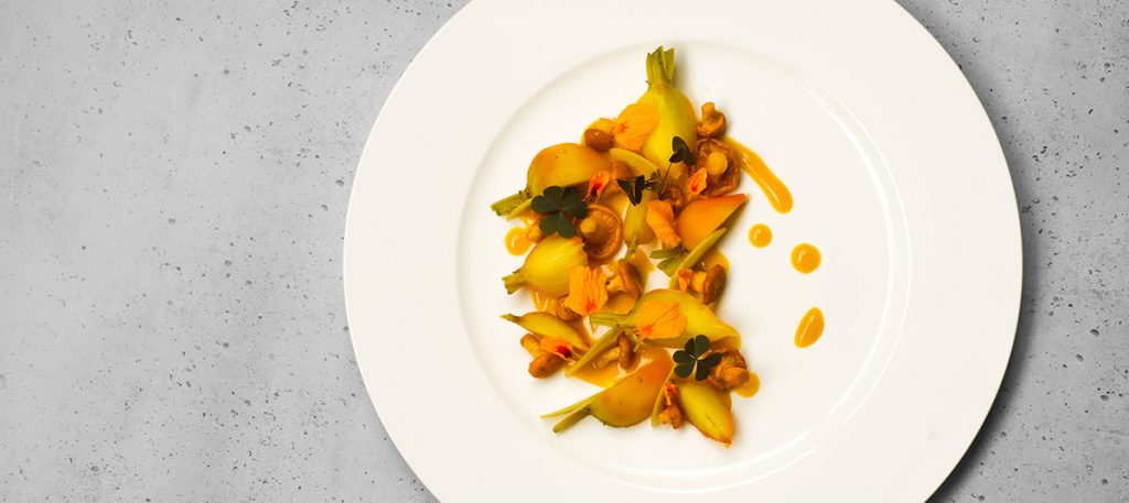 Teller mit glasierten gelbe Bete, sautierten Pfifferlingen und einer Sauce aus gelben Kapuzinerkresse-Blüten