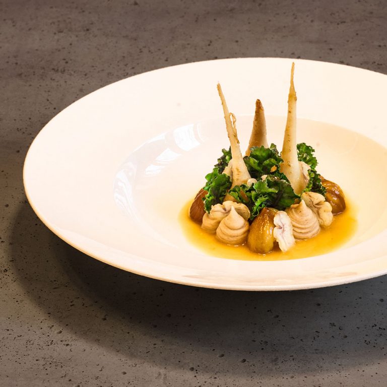 Ein Teller mit glacierten Teltowe Rübchen, glacierten Maronen (Esskastanien), Maronenpüree, rohen Maronenscheiben und blanchierten Fower Sprouts.